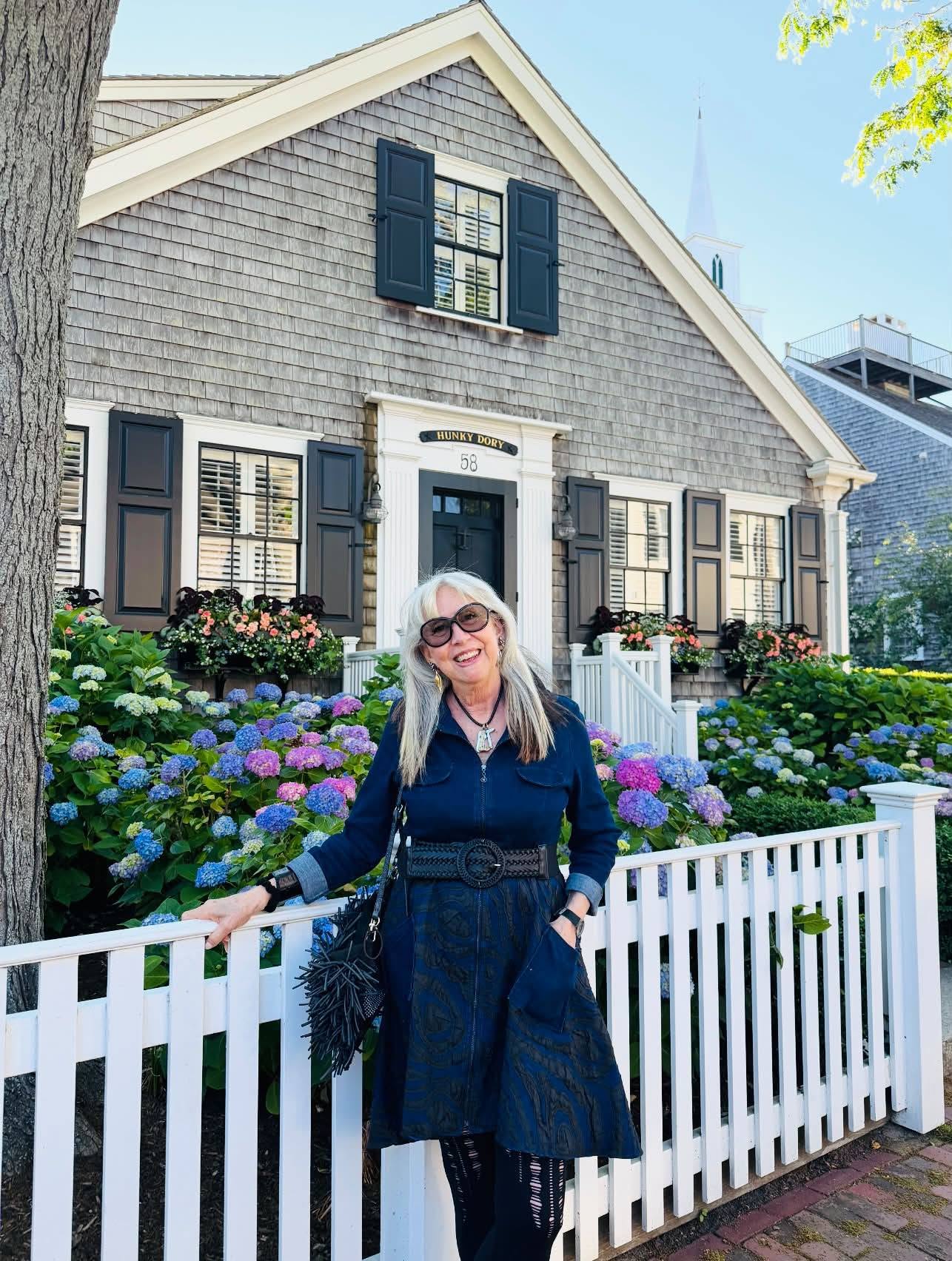 Bonnie Roseman in front of a Nantucket shingled cottage with hydrangeas